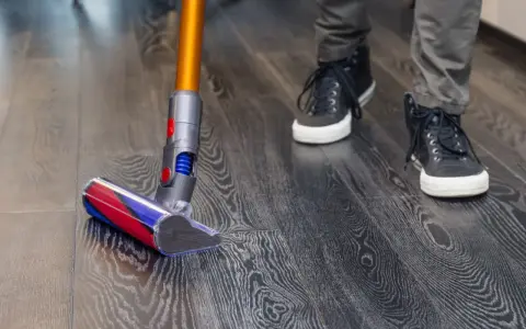 Aspiradora moderna limpia suelo vinílico con acabado de madera. Paso a paso, como limpiar suelo vinilico para un hogar impecable.