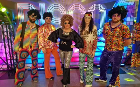 Grupa przyjaciół postanowiła się ubrać w stylu lat 90. na imprezę disco. Kolorowe stroje, peruki i błyszczące dodatki tworzą niezapomnianą atmosferę.