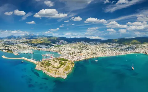 Widok na zamek i zatokę pełną łodzi. Czy to Bodrum, czy Alanya? Piękne turkusowe morze i białe domy na wzgórzach.