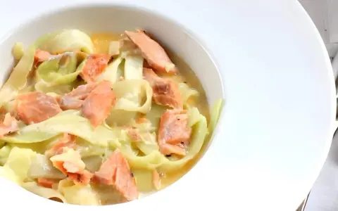 Deliciosos tallarines de calabacín con trozos de salmón rosado en una cremosa salsa. Un plato ligero y sabroso.
