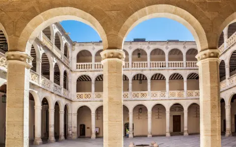 Patio interior con arquerías de varios pisos, columnas y balcones, todo en un elegante estilo renacentista arquitectura.