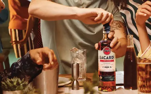Otwieranie butelki Bacardi Spiced, rumu z naturalnymi aromatami i przyprawami, na imprezie.