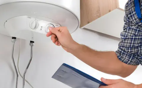 Técnico ajusta el control de temperatura de un termo eléctrico que no enciende.