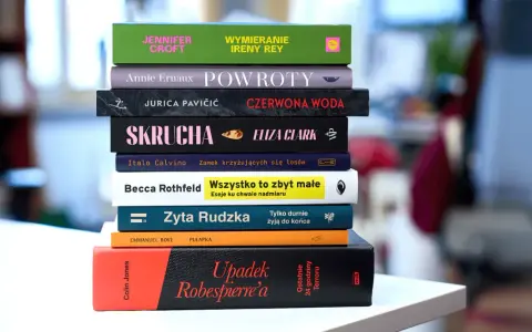 Stos książek, w tym "Upadek Robespierre'a" i "Wszystko to zbyt małe". Anna Klara Majewska mogłaby je czytać.
