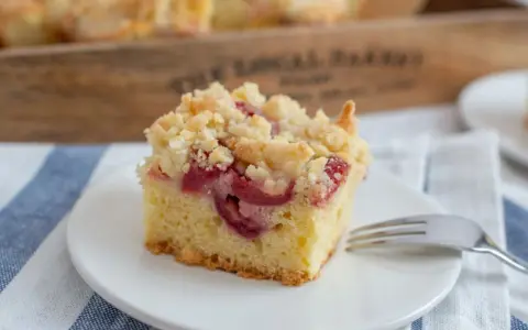 Ein Stück Kirsch-Streuselkuchen, perfekt für ein einfaches Crumble Rezept. Saftige Kirschen unter knusprigen Streuseln.