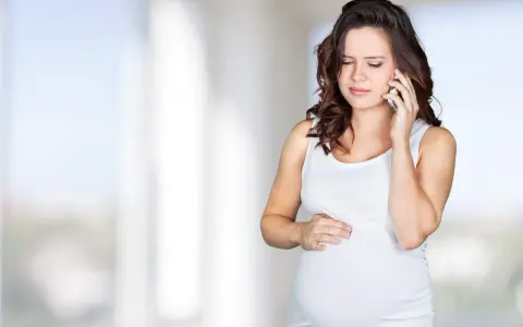 Gravid kvinna med orolig min ringer om sina Braxton Hicks sammandragningar.