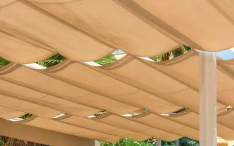Techar patio económico con toldo de tela beige ondulado, creando un espacio sombreado y fresco.