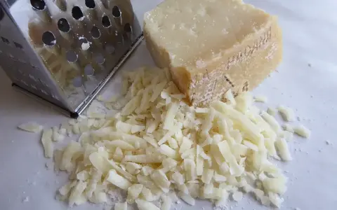Tarka i kawałek sera, z którego właśnie zrobiono garść tartego parmezanu. Idealny do posypania makaronu.