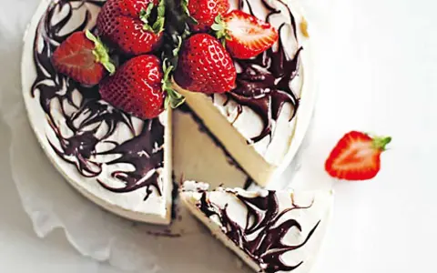 En krämig no bake cheesecake med chokladdrizzle och färska jordgubbar. En bit är uppskuren.
