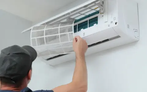 Un technicien nettoie le filtre d'une climatisation réversible. Un entretien régulier assure un air sain et optimise le tarif entretien clim réversible.