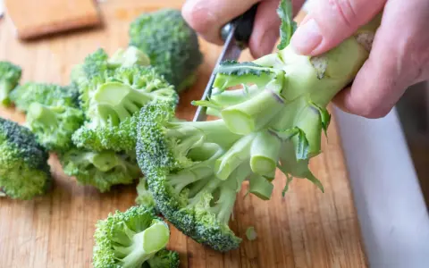 Färska broccolibuketter på en skärbräda, redo att tillagas för att bevara alla nyttiga vitaminer.