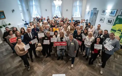 Grupa osób trzyma tabliczki z napisami, m.in. "SOŁTYSKI", "Podnosimy wyzwania", "Ale ENERGIA!".