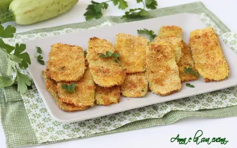 Cotolette di zucchine dorate e croccanti, guarnite con prezzemolo fresco. Un contorno sfizioso e leggero.