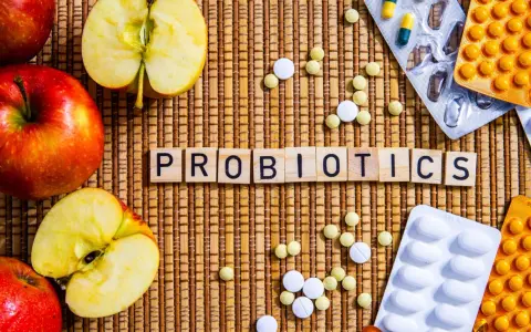 Äpfel und Pillen umgeben das Wort "PROBIOTICS". Eine natürliche Methode, probiotika gegen akne zu finden.