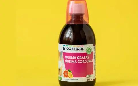 Botella de líquido quemagrasas con etiqueta rosa y naranja sobre fondo amarillo.
