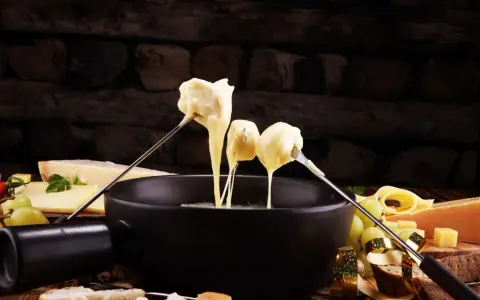 Fondue au fromage, une des spécialités culinaires parisiennes, servie avec du pain et des raisins.
