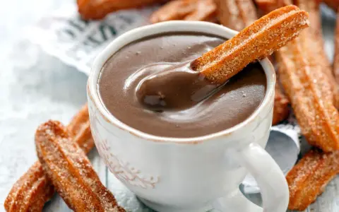 Ein Churro-Rezept zum Genießen: Knusprige Churros werden in heiße Schokolade getunkt.