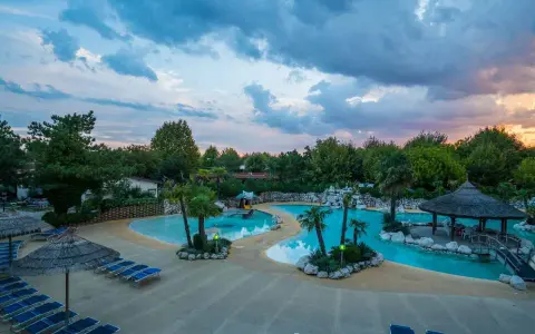 Villaggio vacanze con piscine azzurre, palme e lettini prendisole. Un angolo di paradiso, un vero tahiti camping village.