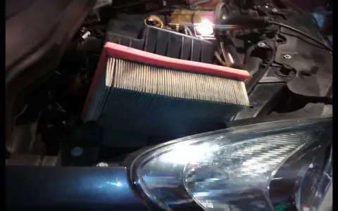Wymiana filtra kabinowego Opel Corsa D. Nowy filtr czeka na montaż w komorze silnika.