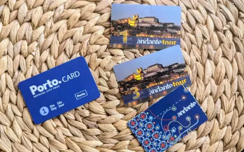 Porto.CARD und Andante Tour-Karten liegen auf einem geflochtenen Untergrund. Perfekt für eine Entdeckungsreise in Porto.