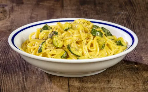 Spaghetti cremosi con zucchine, un'interpretazione fresca della carbonara di zucchine, guarniti con pepe nero macinato.