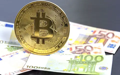 Moneda de Bitcoin sobre billetes de euro. El futuro del euro digital podría ser así.