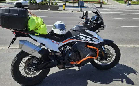 Motocykl KTM 790 Adventure gotowy na przygodę po NC500 Szkocja. Kask i jaskrawożółty pokrowiec na bagaż czekają na start.