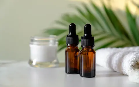 Dwa brązowe flakoniki z pipetką i słoiczek z kremem, obok biały ręcznik. Zastanawiasz się, czy serum można stosować codziennie?
