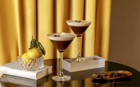 Zwei elegante Gläser mit cremigem Espresso-Martini-Look, garniert mit Kaffeebohnen. Ein alkoholfreier Genuss, der Luxus ausstrahlt.