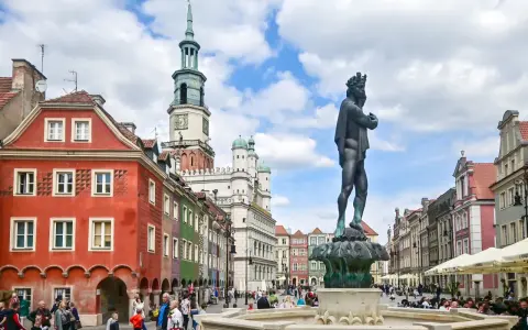 Rynek w Poznaniu z fontanną i kolorowymi kamienicami.