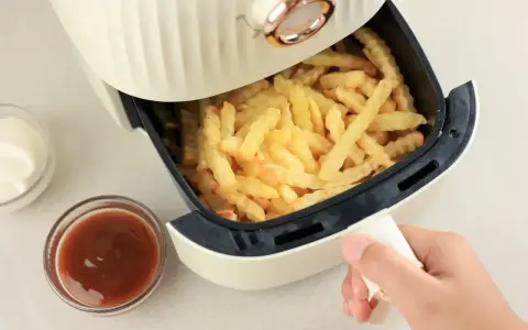 Air fryer co to? To urządzenie, które przygotuje chrupiące frytki bez nadmiaru tłuszczu. Obok sosy i majonez.