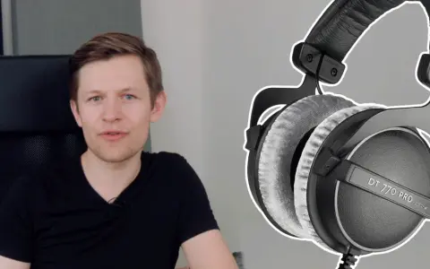 Mężczyzna w czarnej koszulce obok słuchawek do mixu Beyerdynamic DT 770 PRO.