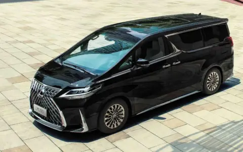 Elegancki, czarny Lexus LM 350h lśni na tle jasnej kostki brukowej.