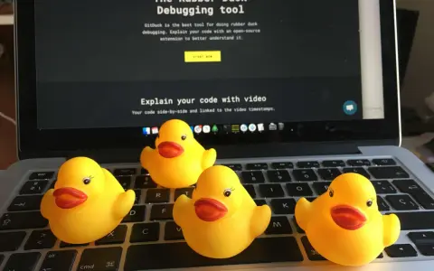 Cztery żółte gumowe kaczuszki siedzą na klawiaturze laptopa, obok ekranu z napisem "The Rubber Duck Debugging tool".