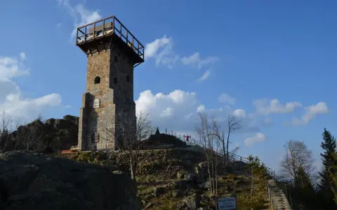 Wysoki kamień, wieża widokowa na szczycie góry, z drewnianym tarasem i schodami prowadzącymi do niej.