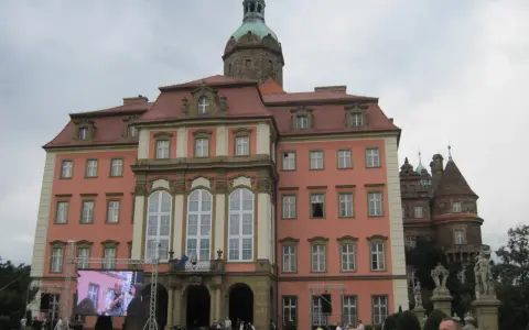Zamek Książ z wieżą i ekranem LED przed fasadą, na którym wyświetlany jest obraz.