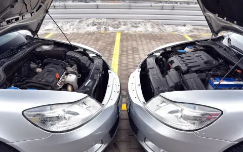 Dwa silniki samochodowe, jeden diesel, drugi benzyna, stoją obok siebie. Różnice w budowie są widoczne, choć oba napędzają auta.