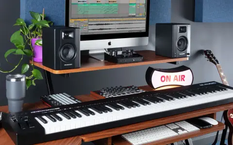 M-Audio Keystation 61, monitory studyjne, komputer z programem do produkcji muzyki, gitara i lampa "ON AIR" tworzą profesjonalne studio.