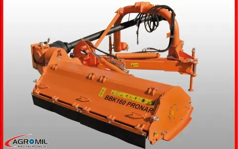 Pomarańczowa kosiarka tylno boczna BBK160 PRONAR z wałkiem WOM i elementami hydraulicznymi, gotowa do pracy w polu.