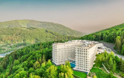 Nowoczesny hotel wtopiony w zieleń gór, przypominający kształtem górę czaszki.