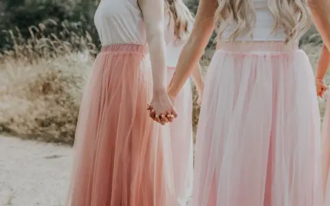 Dziewczyny w tiulowych, pudrowych sukienkach trzymają się za ręce. Ich styl to kwintesencja "soft girl".