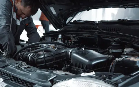 Mechanik pracuje przy silniku, przygotowując się do odpowietrzenia sprzęgła 1.9 TDI.