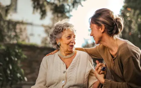 Un legame forte tra madre e figlia adulta, un abbraccio che simboleggia la dipendenza dalla madre in età adulta, ma anche amore e cura.