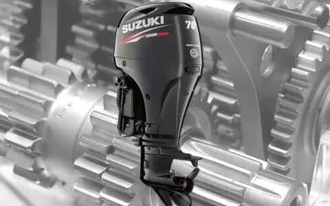 Moteur hors-bord Suzuki DF 70, vu sur fond de rouages mécaniques. Une image pour la revue technique.