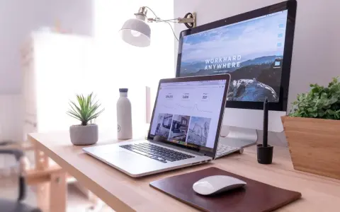 Escritorio moderno con laptop y monitor, ideal para un master business administration online.