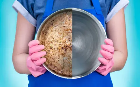 Una padella in acciaio divisa a metà: da un lato incrostata e sporca, dall'altro lucida e pulita.
