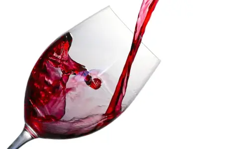 Czerwone wino leje się do kieliszka, tworząc wiry. Ile promili w lampce?