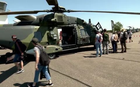 Besucher bestaunen deutsche Hubschrauber auf einem Flugplatz.