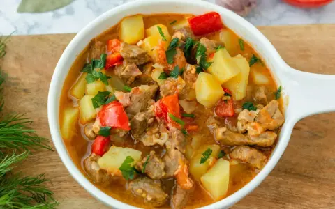 Aksamitna, aromatyczna najlepsza zupa gulaszowa z kawałkami mięsa, ziemniaków i papryki, posypana świeżą natką pietruszki.