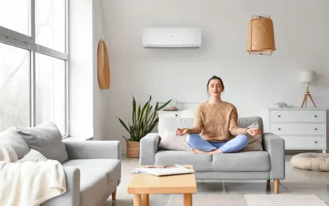 Donna medita in un soggiorno confortevole, con un condizionatore d'aria inverter che garantisce un clima ideale per il relax.